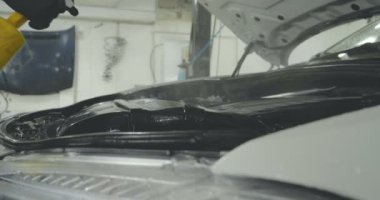 Çalışan siyah bir araba parlatır bir profesyonel, tamir araba, çocuk arabaları, oto yıkama, servis, Profesyonel Araba Seramik İşçi araba camları seramik (koruyucu yağmur kapağı) bir tabaka uygular. Konsept: Nano Koruma, Farklı acces