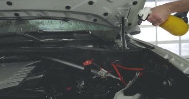 Çalışan siyah bir araba parlatır bir profesyonel, tamir araba, çocuk arabaları, oto yıkama, servis, Profesyonel Araba Seramik İşçi araba camları seramik (koruyucu yağmur kapağı) bir tabaka uygular. Konsept: Nano Koruma, Farklı acces