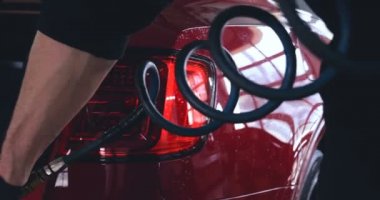 Profesyonel işçiler bir araba yıkamadan sonra çizikler için araba kontrol, sonra Lehçe ve kırmızı bir araba üzerinde temiz. Kavramı: manuel araba yıkama, kırmızı.