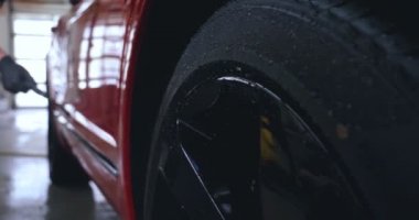 Profesyonel işçiler bir araba yıkamadan sonra çizikler için araba kontrol, sonra Lehçe ve kırmızı bir araba üzerinde temiz. Kavramı: manuel araba yıkama, kırmızı.