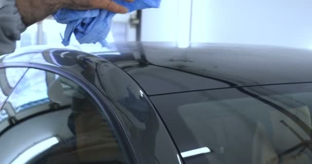 员工是一个专业谁抛光黑色汽车 维修汽车 儿童车 专业汽车陶瓷工人应用一层陶瓷 保护雨罩 在车窗上 概念来自 纳米保护 不同功能 — 图库视频影像