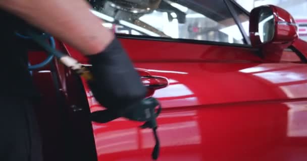 プロの労働者は洗車の後に傷のために車をチェックし ポリッシュし 赤い車の上にそれをきれいにします コンセプト マニュアルカーウォッシュ レッド — ストック動画