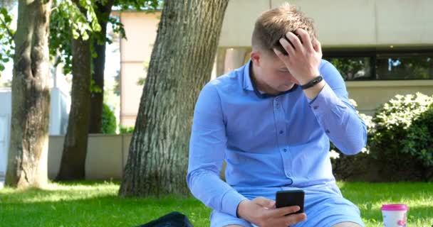 Homme Utilisant Une Tablette Informatique Sous Arbre Dans Parc Côté — Video