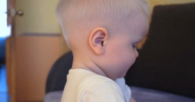 TV 'de bir çocuk ile genç bir baba, birbirlerine sevgi dolu el tutan karikatür izlerken, mutlu atlama oynuyor. Baba sarılıyor ve öpücük oğul.