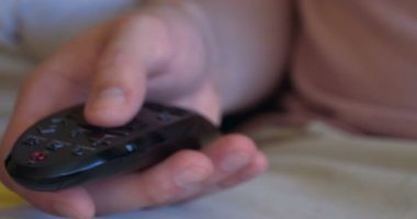 TV 'de bir çocuk ile genç bir baba, birbirlerine sevgi dolu el tutan karikatür izlerken, mutlu atlama oynuyor. Baba sarılıyor ve öpücük oğul.