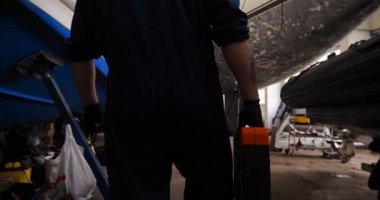 Genç yakışıklı profesyonel adam (erkek) temizleyici, yat parlatma ve astar seramikten sonra yat yıkıyor. Yat teknisyeni, çamurdan bir kimyasal sprey (boya) temizleyici kullanarak pervaneyi temizler. Konsept: yeni teknik, kimya, Profesi