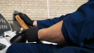 Genç yakışıklı profesyonel adam (erkek) temizleyici, yat parlatma ve astar seramikten sonra yat yıkıyor. Yat teknisyeni, çamurdan bir kimyasal sprey (boya) temizleyici kullanarak pervaneyi temizler. Konsept: yeni teknik, kimya, Profesi