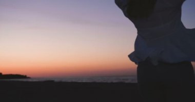 Romantik Çift bir sahilde rahatlatır, yangın kahve yapma. Ve yaşamın keyfini, denizin üzerinde gün batımı hayran. Sahil için inanılmaz seyahat. Arka ışık, Çift yaz tatili gün batımı deniz restoranda şarap içme.