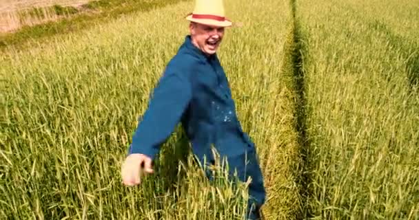 一个年轻人 一个穿着工作服的农民 站在田野里深深地吸气 在阳光明媚的日子里感受自由 生活方式 慢动作 — 图库视频影像