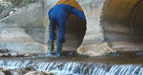 Engenheiro Trabalhador Verifica Calhas Roupão Azul Botas Capacete Amarelo Construção — Vídeo de Stock