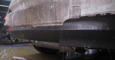 Profesyonel, arabayı siyah eldivenlerle, sünger ve köpükle yıkar. Konsept: Oto yıkama, sünger, köpük, su, profesyonel, iş.