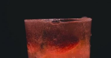 Barmen, bir parti için çeşitli içecekler (kokteyller) hazırlar. Disko veya evde barda meyve soğuk içecekler siyah arka planda görülür.