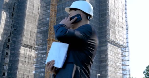 スーツを着た成功した若いハンサムなエンジニア 建築家 建築家 ビジネスマンの肖像画は メモ帳 超高層ビルの背景や建物を保持 — ストック動画