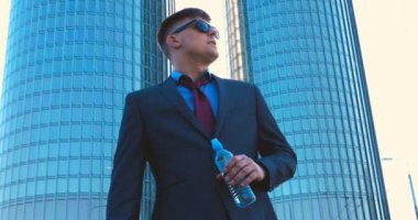 Genç bir adam (erkek) mimar, takım elbiseli bir işadamı, elinde tabletli bir klasör (cep telefonu) olan bir ceket içinde inşaat alanını ve iş binasını çeşitli eylemlerle kontrol ediyor..