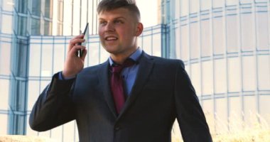 Genç bir adam (erkek) mimar, takım elbiseli bir işadamı, elinde tabletli bir klasör (cep telefonu) olan bir ceket içinde inşaat alanını ve iş binasını çeşitli eylemlerle kontrol ediyor..