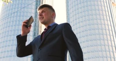 Genç bir adam (erkek) mimar, takım elbiseli bir işadamı, elinde tabletli bir klasör (cep telefonu) olan bir ceket içinde inşaat alanını ve iş binasını çeşitli eylemlerle kontrol ediyor..