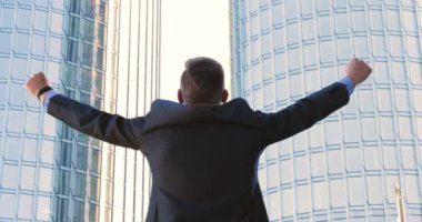 Genç bir adam (erkek) mimar, takım elbiseli bir işadamı, elinde tabletli bir klasör (cep telefonu) olan bir ceket içinde inşaat alanını ve iş binasını çeşitli eylemlerle kontrol ediyor..