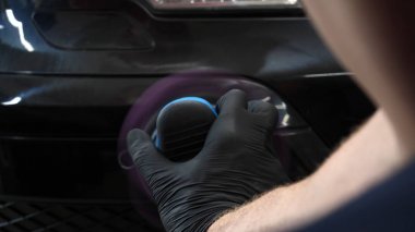 Profesyonel bir kaporta ve far cilası işçisi arabayı boyamadan veya satışa hazırlandıktan sonra taşır. Taze arabalar, Otomotiv Merkezi, Hizmet, Profesyonel.