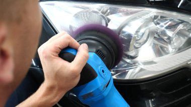 Profesyonel bir kaporta ve far cilası işçisi arabayı boyamadan veya satışa hazırlandıktan sonra taşır. Taze arabalar, Otomotiv Merkezi, Hizmet, Profesyonel.