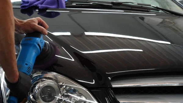 Profesyonel bir kaporta ve far cilası işçisi arabayı boyamadan veya satışa hazırlandıktan sonra taşır. Taze arabalar, Otomotiv Merkezi, Hizmet, Profesyonel.