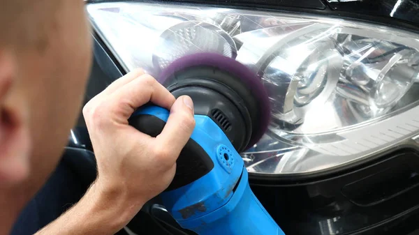 Profesyonel bir kaporta ve far cilası işçisi arabayı boyamadan veya satışa hazırlandıktan sonra taşır. Taze arabalar, Otomotiv Merkezi, Hizmet, Profesyonel.