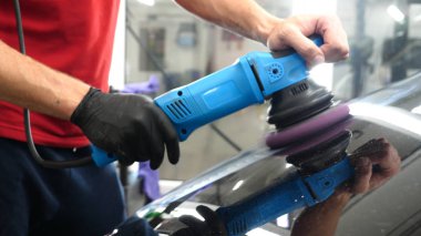 Profesyonel bir kaporta ve far cilası işçisi arabayı boyamadan veya satışa hazırlandıktan sonra taşır. Taze arabalar, Otomotiv Merkezi, Hizmet, Profesyonel.