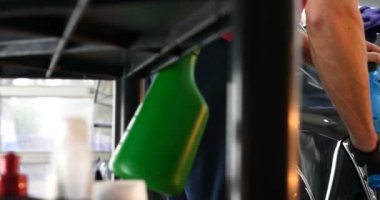 Profesyonel bir kaporta ve far cilası işçisi arabayı boyamadan veya satışa hazırlandıktan sonra taşır. Taze arabalar, Otomotiv Merkezi, Hizmet, Profesyonel.