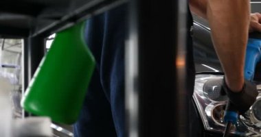 Profesyonel bir kaporta ve far cilası işçisi arabayı boyamadan veya satışa hazırlandıktan sonra taşır. Taze arabalar, Otomotiv Merkezi, Hizmet, Profesyonel.
