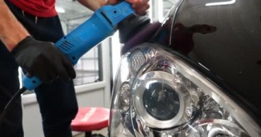 Profesyonel bir kaporta ve far cilası işçisi arabayı boyamadan veya satışa hazırlandıktan sonra taşır. Taze arabalar, Otomotiv Merkezi, Hizmet, Profesyonel.