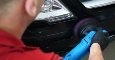 Profesyonel bir kaporta ve far cilası işçisi arabayı boyamadan veya satışa hazırlandıktan sonra taşır. Taze arabalar, Otomotiv Merkezi, Hizmet, Profesyonel.