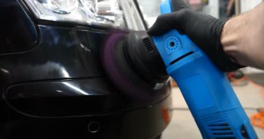 Profesyonel bir kaporta ve far cilası işçisi arabayı boyamadan veya satışa hazırlandıktan sonra taşır. Taze arabalar, Otomotiv Merkezi, Hizmet, Profesyonel.