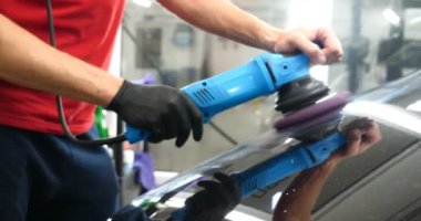 Profesyonel bir kaporta ve far cilası işçisi arabayı boyamadan veya satışa hazırlandıktan sonra taşır. Taze arabalar, Otomotiv Merkezi, Hizmet, Profesyonel.