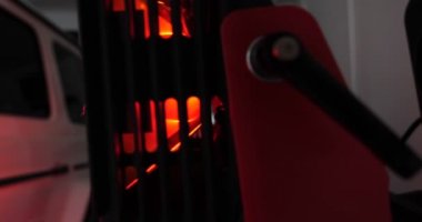 Vücut parçalarının kızılötesi kuruması macun sürdükten sonra ve çalışma ortamında çalışan kırmızı fenerlerle tamirhanedeki beyaz bir off-road aracına boya sürdükten sonra. Araba Seramik, Yavaş Hareket kavramı.