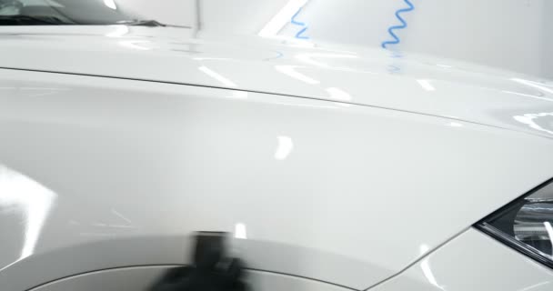 这位专业的工人手里拿着一块白色的海绵 用液体 汽车修理店 在汽车车库擦亮和喷漆后 用手电筒检查汽车 — 图库视频影像
