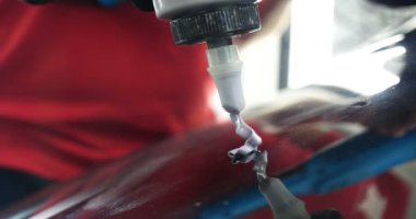 Profesyonel bir kaporta ve far cilası işçisi arabayı boyamadan veya satışa hazırlandıktan sonra taşır. Taze arabalar, Otomotiv Merkezi, Hizmet, Profesyonel.