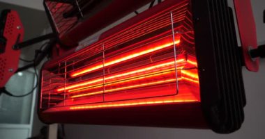 Vücut parçalarının kızılötesi kuruması macun sürdükten sonra ve çalışma ortamında çalışan kırmızı fenerlerle tamirhanedeki beyaz bir off-road aracına boya sürdükten sonra. Araba Seramik, Yavaş Hareket kavramı.