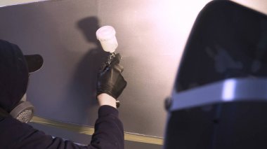 Garajda profesyonel bir adam (adam) bir mini-jet (spreyler) ile bir koruyucu takım dispenser ve koruyucu gözlük kullanarak yüzeye boya (seramik) uygulayarak yat (ulaşım) kapsar.