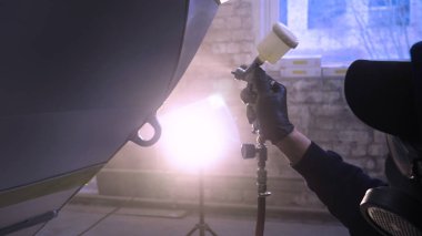 Garajda profesyonel bir adam (adam) bir mini-jet (spreyler) ile bir koruyucu takım dispenser ve koruyucu gözlük kullanarak yüzeye boya (seramik) uygulayarak yat (ulaşım) kapsar.