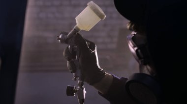 Garajda profesyonel bir adam (adam) bir mini-jet (spreyler) ile bir koruyucu takım dispenser ve koruyucu gözlük kullanarak yüzeye boya (seramik) uygulayarak yat (ulaşım) kapsar.