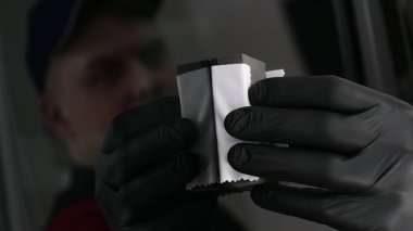 Profesyonel bir erkek (erkek) bir araba seramik ustası bir çekmece, güvenlik gözlükleri ve siyah eldiven bir fiber (sünger) bez kullanarak bir araba seramik koyar.