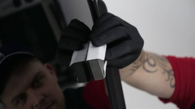 Profesyonel bir erkek (erkek) bir araba seramik ustası bir çekmece, güvenlik gözlükleri ve siyah eldiven bir fiber (sünger) bez kullanarak bir araba seramik koyar.