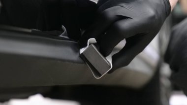 Profesyonel bir erkek (erkek) bir araba seramik ustası bir çekmece, güvenlik gözlükleri ve siyah eldiven bir fiber (sünger) bez kullanarak bir araba seramik koyar.