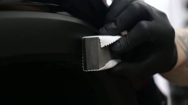 Profesyonel bir erkek (erkek) bir araba seramik ustası bir çekmece, güvenlik gözlükleri ve siyah eldiven bir fiber (sünger) bez kullanarak bir araba seramik koyar.