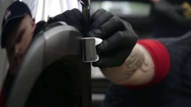 Profesyonel bir erkek (erkek) bir araba seramik ustası bir çekmece, güvenlik gözlükleri ve siyah eldiven bir fiber (sünger) bez kullanarak bir araba seramik koyar.