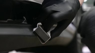 Profesyonel bir erkek (erkek) bir araba seramik ustası bir çekmece, güvenlik gözlükleri ve siyah eldiven bir fiber (sünger) bez kullanarak bir araba seramik koyar.