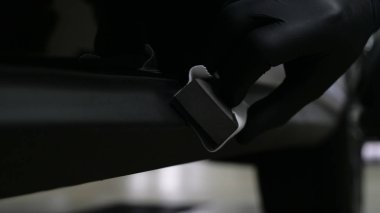 Profesyonel bir erkek (erkek) bir araba seramik ustası bir çekmece, güvenlik gözlükleri ve siyah eldiven bir fiber (sünger) bez kullanarak bir araba seramik koyar.