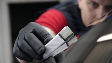 Profesyonel bir erkek (erkek) bir araba seramik ustası bir çekmece, güvenlik gözlükleri ve siyah eldiven bir fiber (sünger) bez kullanarak bir araba seramik koyar.