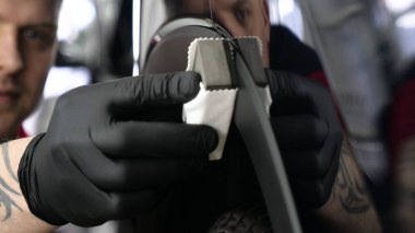 Profesyonel bir erkek (erkek) bir araba seramik ustası bir çekmece, güvenlik gözlükleri ve siyah eldiven bir fiber (sünger) bez kullanarak bir araba seramik koyar.