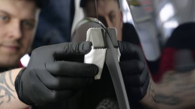 Profesyonel bir erkek (erkek) bir araba seramik ustası bir çekmece, güvenlik gözlükleri ve siyah eldiven bir fiber (sünger) bez kullanarak bir araba seramik koyar.