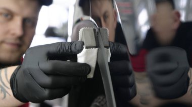 Profesyonel bir erkek (erkek) bir araba seramik ustası bir çekmece, güvenlik gözlükleri ve siyah eldiven bir fiber (sünger) bez kullanarak bir araba seramik koyar.